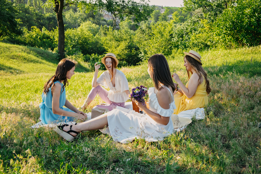 Galentines Day. Slumber Party. Summer Picnic Party Ideas, Outdoor Gathering with Friends. Young Women Girl Friends Drinking Wine, Laughing, Having Fun Together at Picnic.